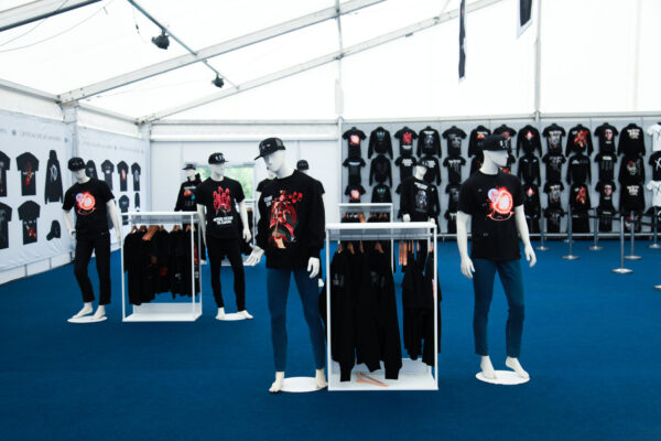 Inside The Weeknd pop-up shop, showing mannequins wearing the merch as well as t-shirts on the wall.