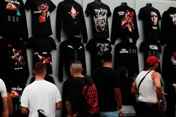 Fans looking at The Weeknd t-shirts displayed on the wall inside the shop.