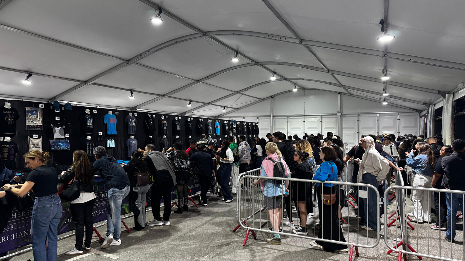 Inside view of Coldplay merchandise with fans queuing